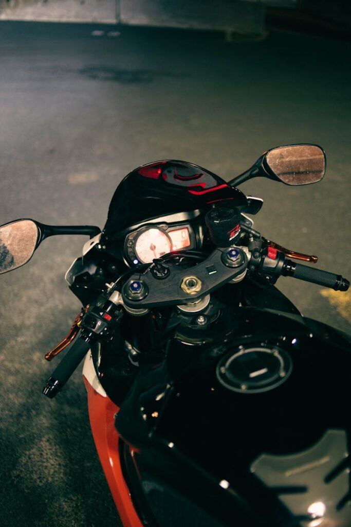 Detailed view of motorcycle handlebars and dashboard in an urban night setting.
