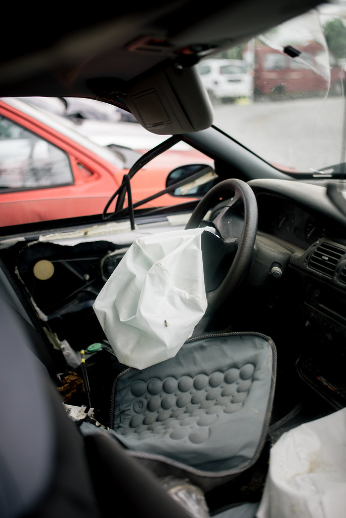 A damaged car with a deployed airbag