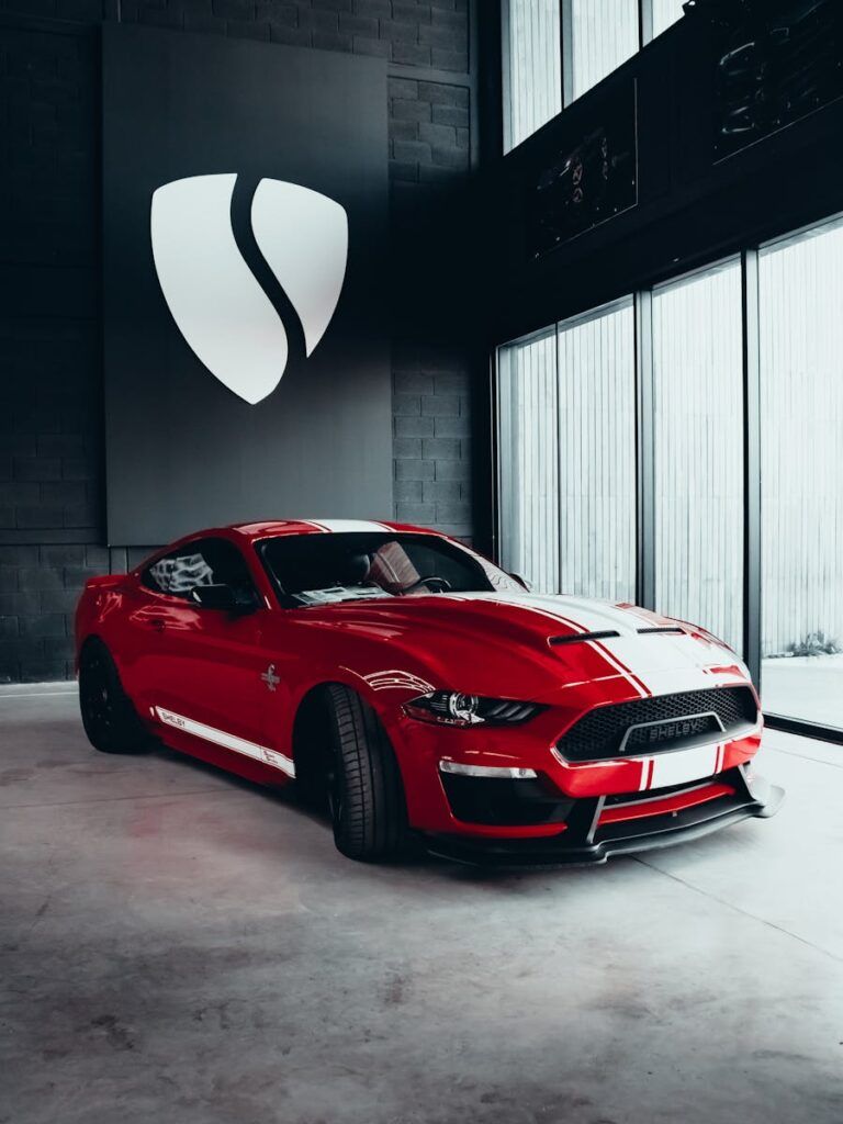 A striking red Shelby Mustang GT sports car displayed in a modern indoor showroom.