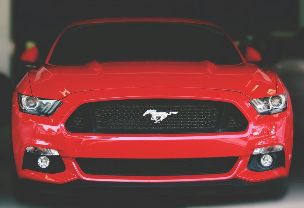 Bright red Ford Mustang showcased with a sleek front view in Ahmedabad.
