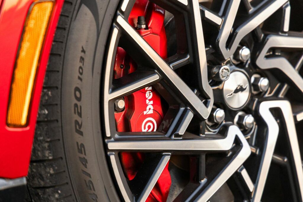 Detailed close-up of a red Brembo brake caliper and alloy wheel showcasing automotive technology.