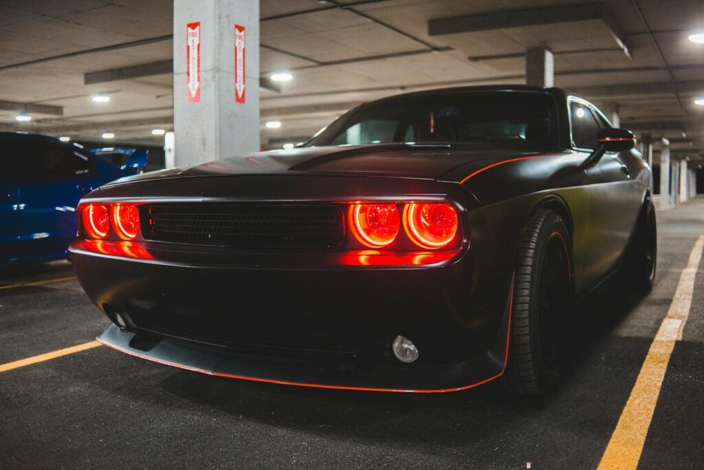 High-performance muscle car showcasing bold headlights in a modern parking garage setting.