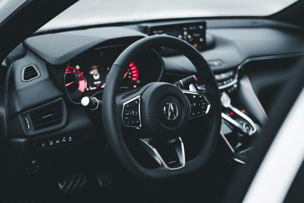 Sleek and modern interior of an Acura car featuring dashboard and steering wheel.
