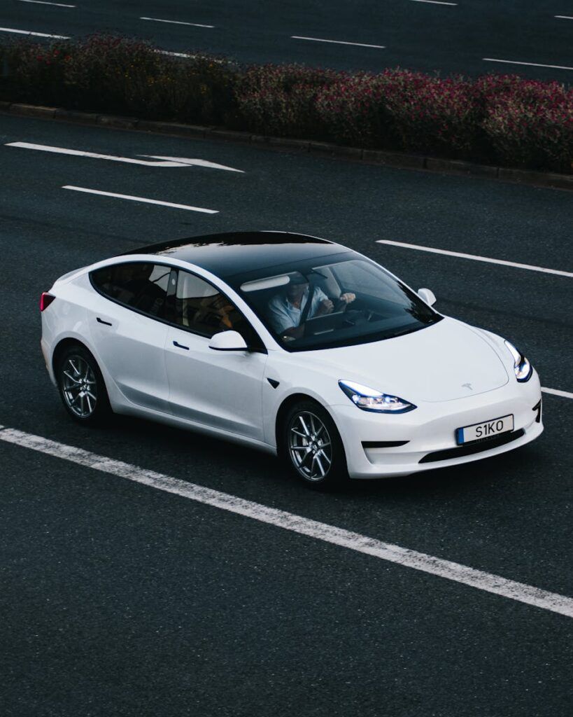 Tesla Model 3 driving on a highway in Osnabrück, Germany, showcasing modern electric vehicle design.