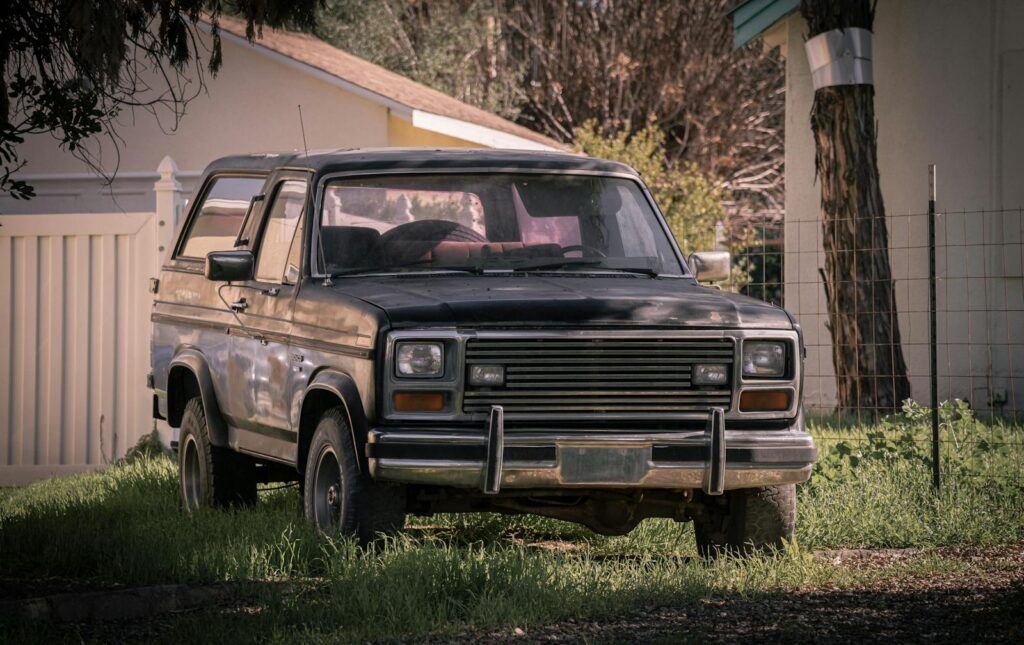 Vintage Ford Bronco SUV parked outdoors in a grassy yard in Redlands, California.
