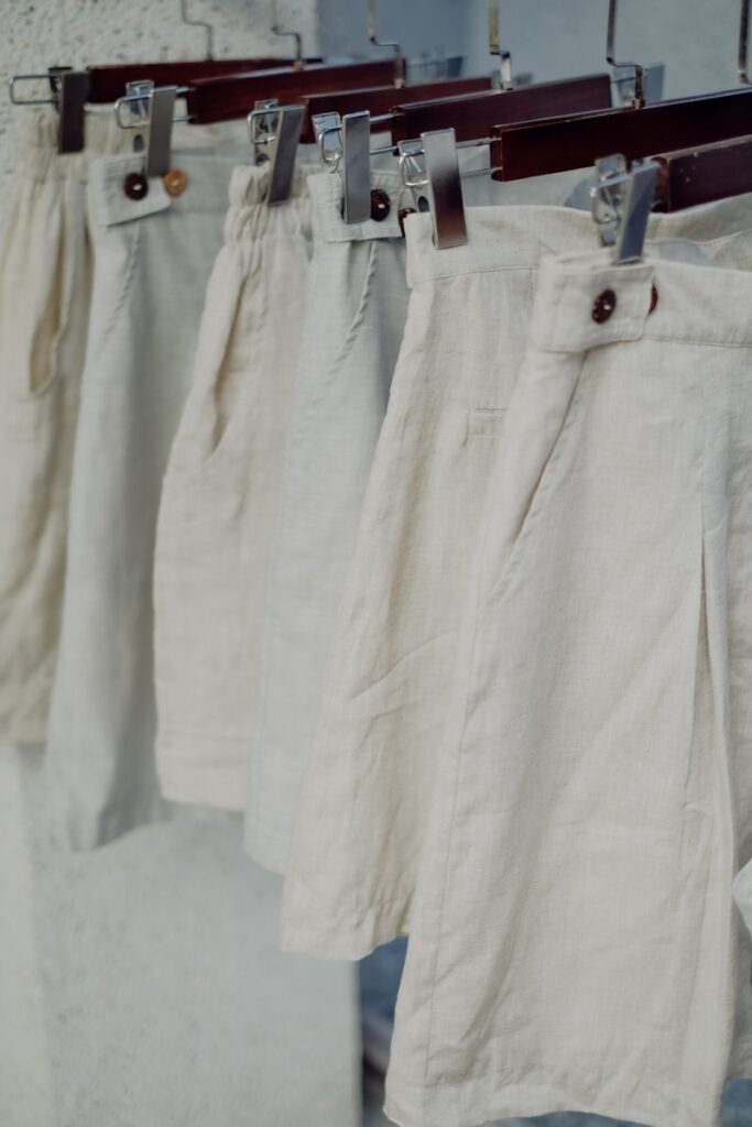 a row of white pants hanging on a clothes line