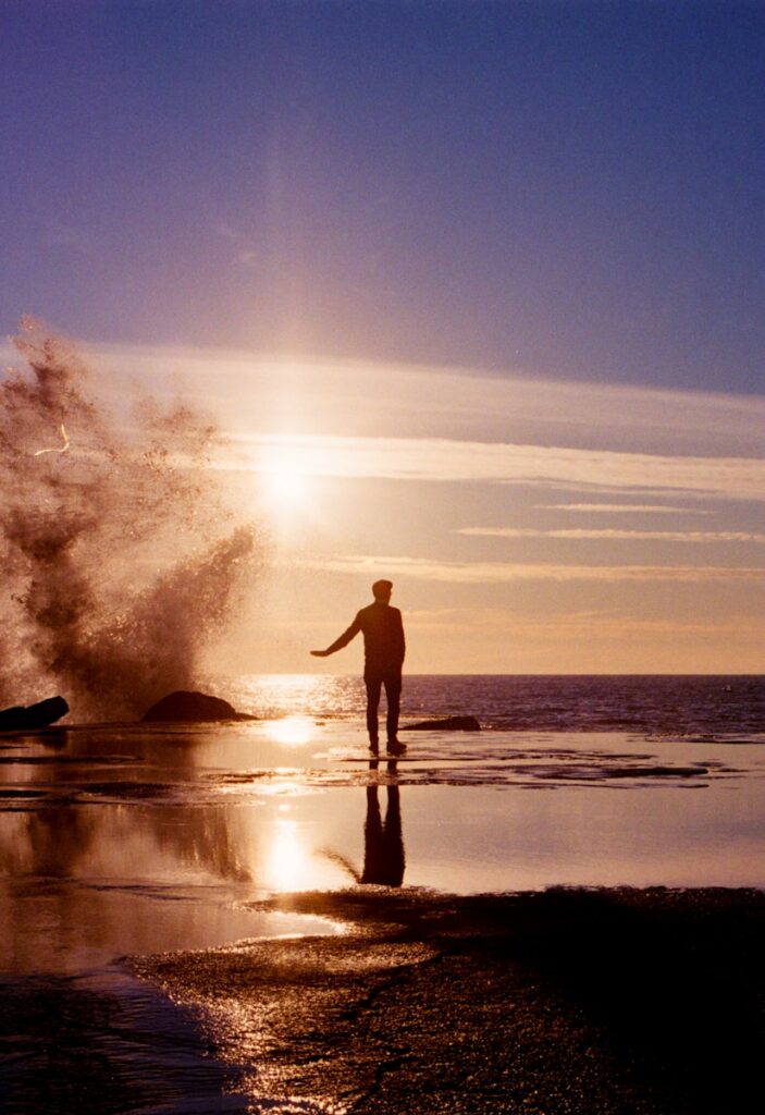 A couple of people standing on top of a beach