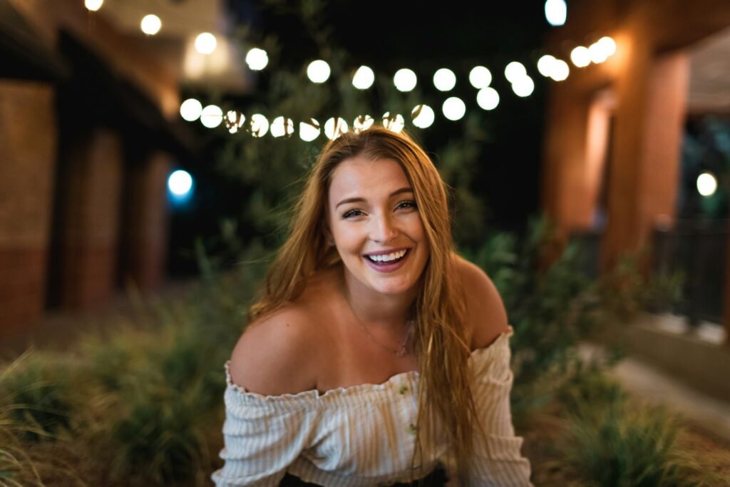 woman in white off shoulder dress smiling