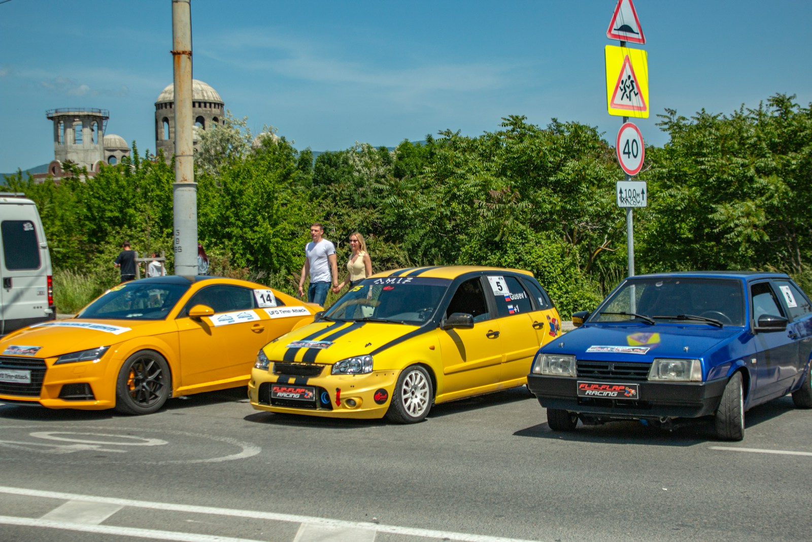Three colorful cars are lined up on a road.