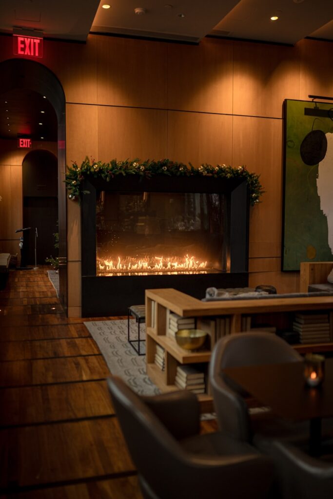 a fire place in a restaurant with chairs and tables