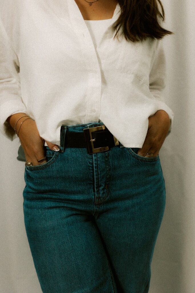 Woman in jeans and shirt with hands in pockets.