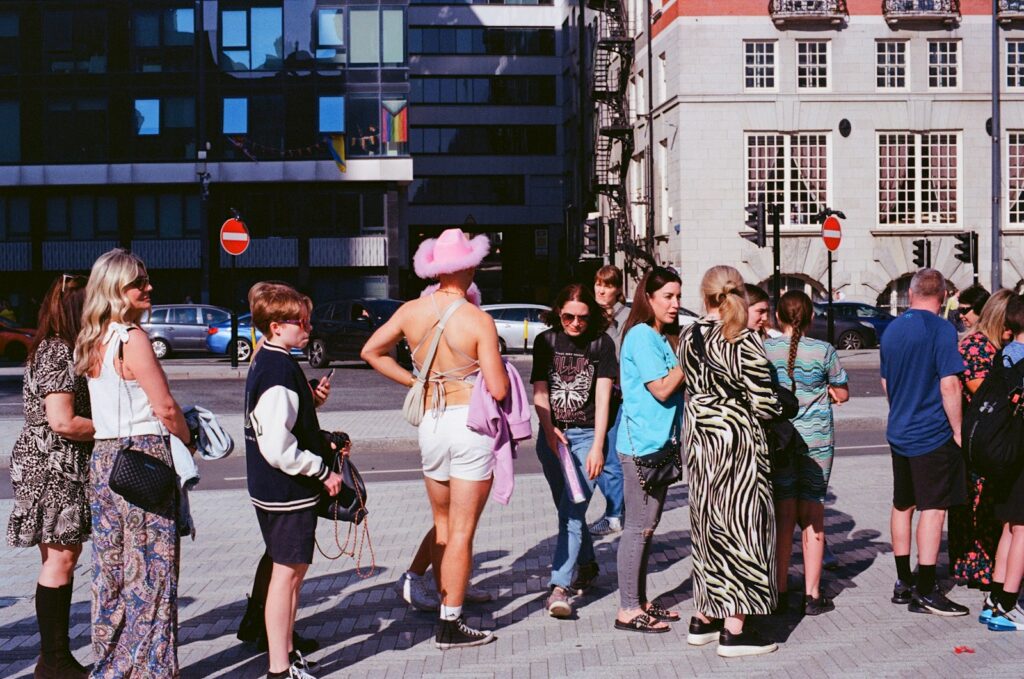a group of people standing on a street corner