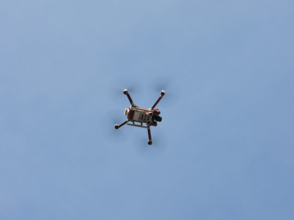 a small helicopter flying through a blue sky