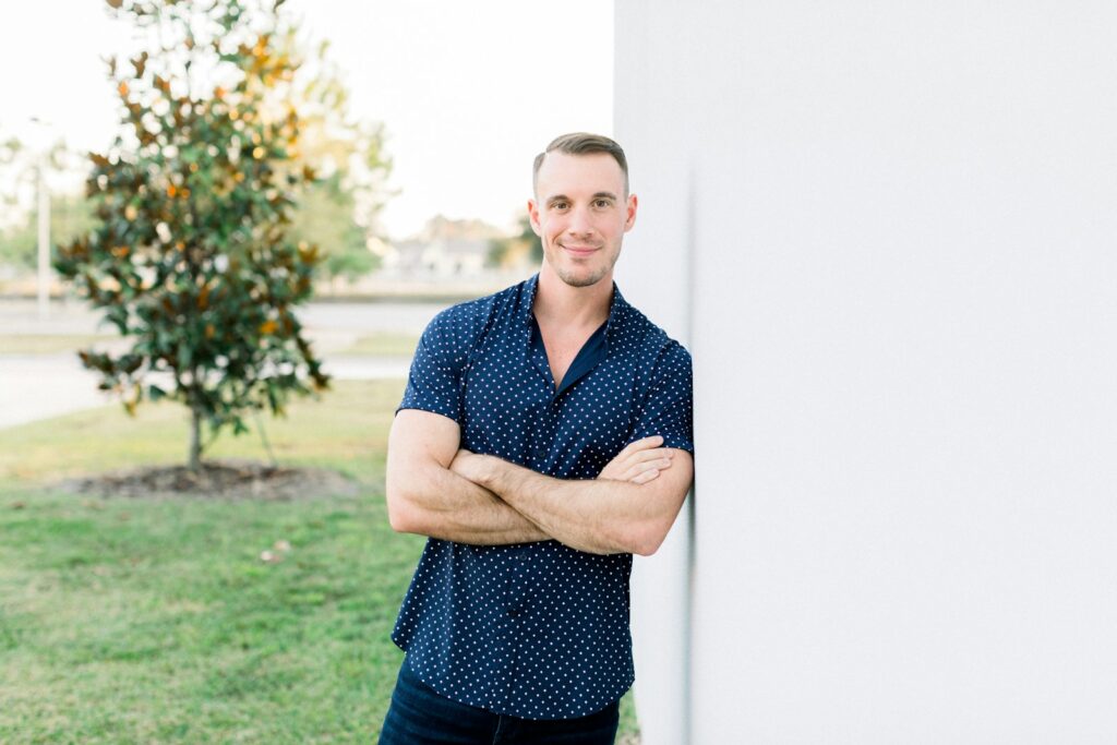 a man leaning against a wall with his arms crossed