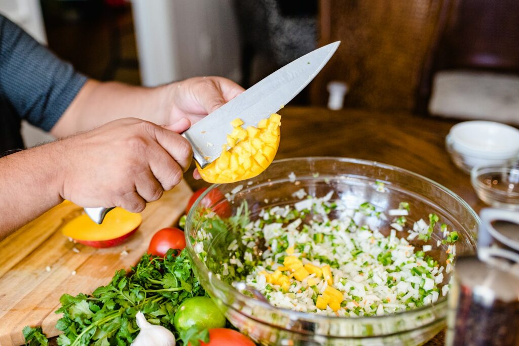 a person cutting up vegetables on a cutting board