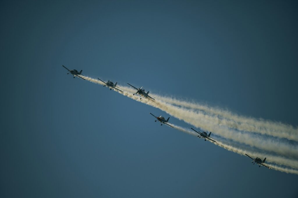 A group of jets flying through a blue sky