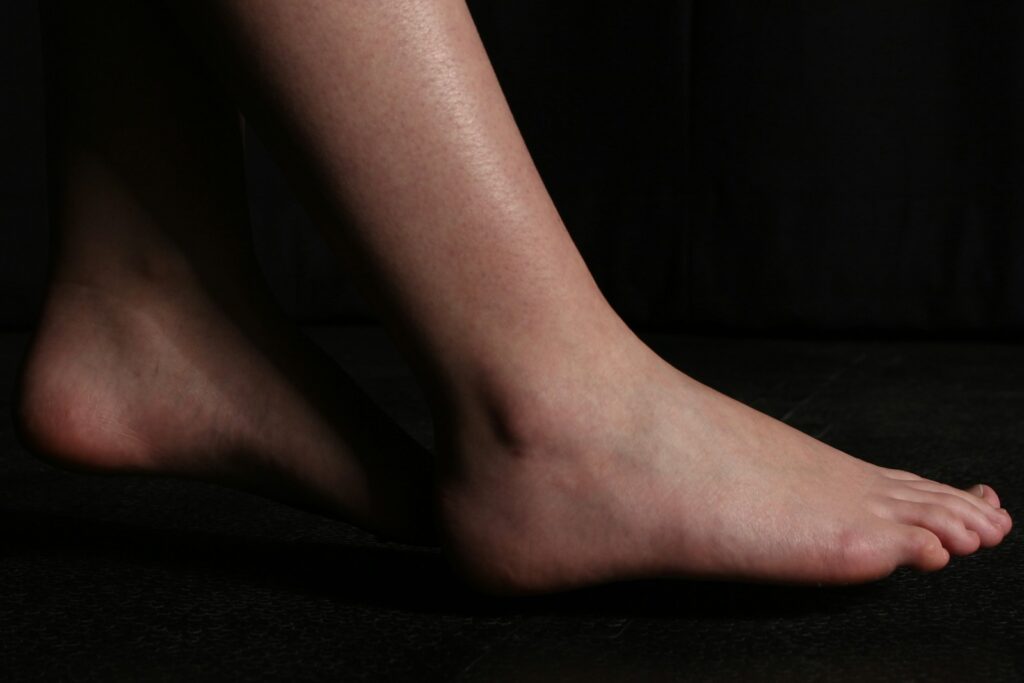 A bare foot is posing on black.
