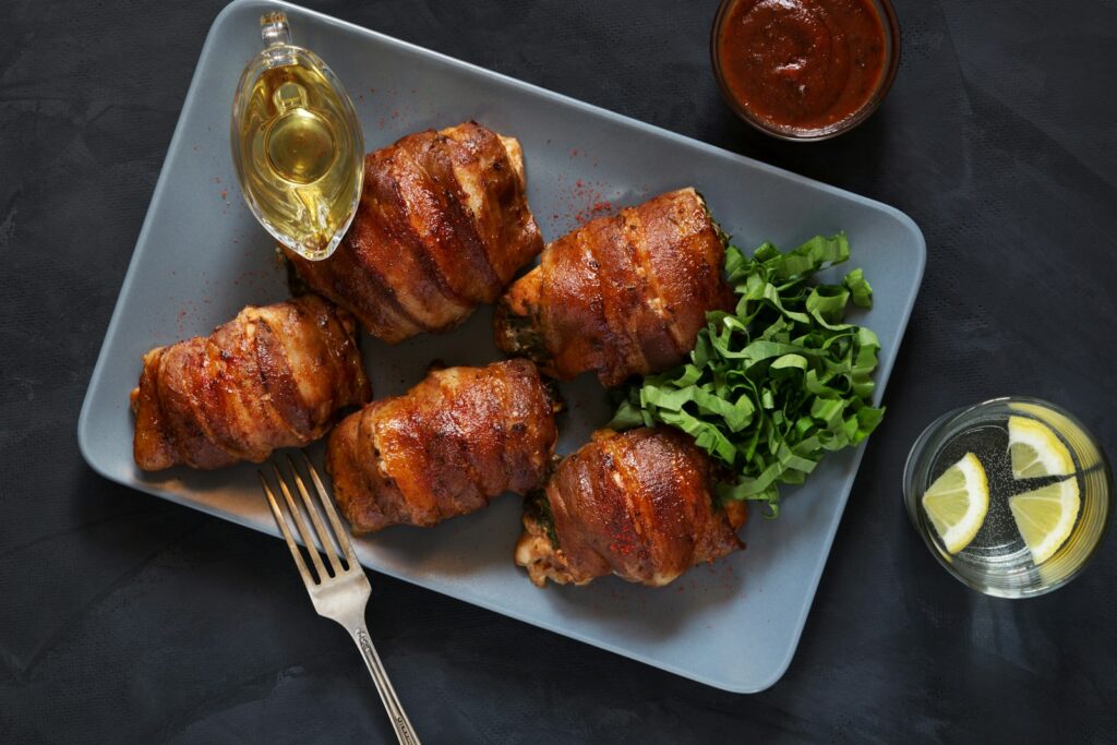 Bacon-wrapped chicken thighs sit ready to be enjoyed.