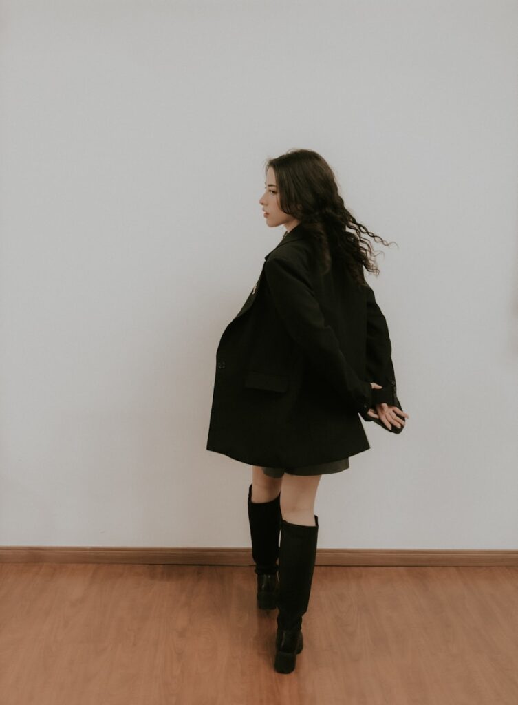 A woman standing in front of a white wall