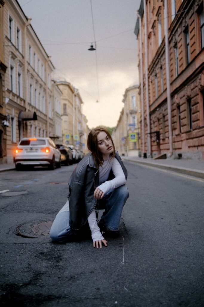 Woman squatted in the middle of an empty street.