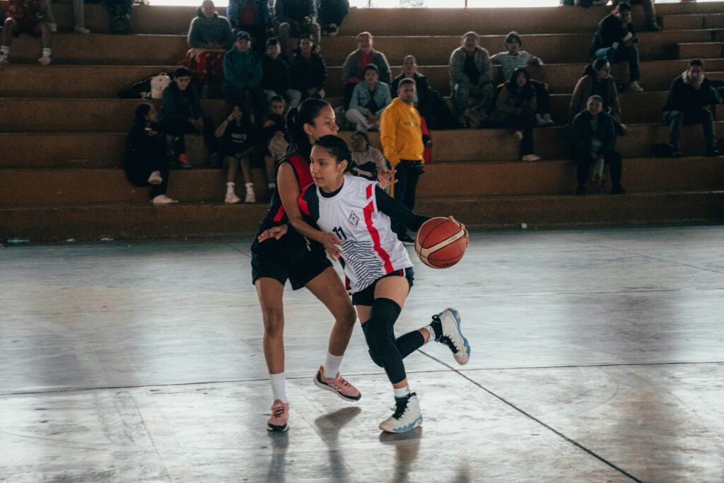 A group of people playing a game of basketball