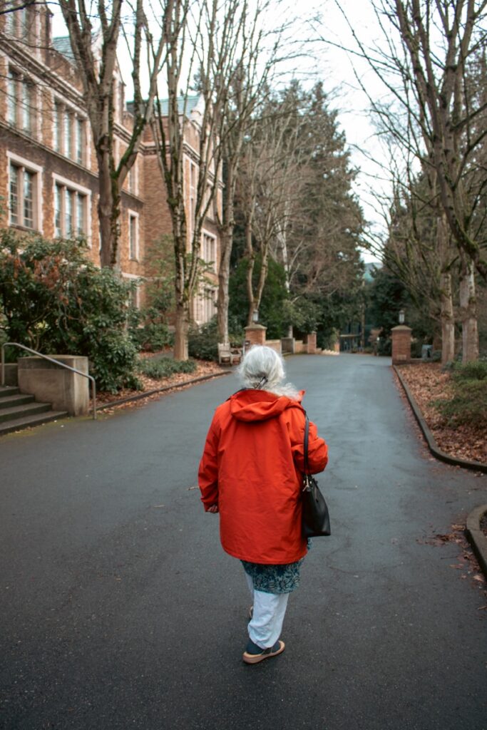 Woman walks down a path in a university setting.