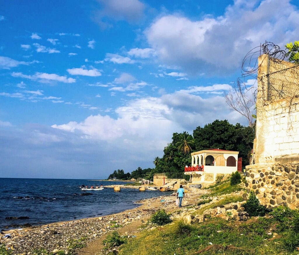 brown concrete building near body of water under blue sky during daytime