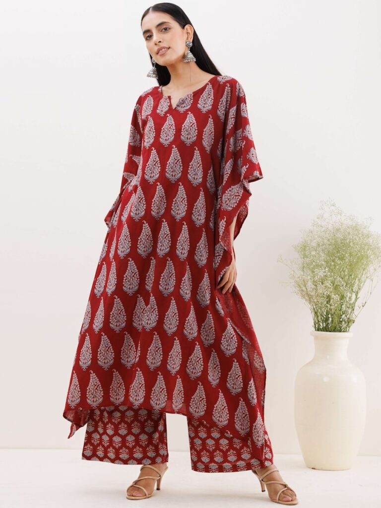 a woman standing in front of a white vase