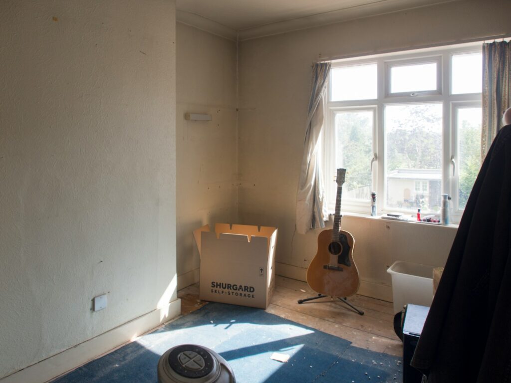 An empty room with a guitar in the corner