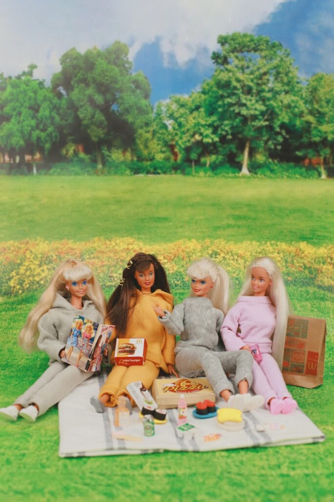 A group of dolls sitting on top of a blanket