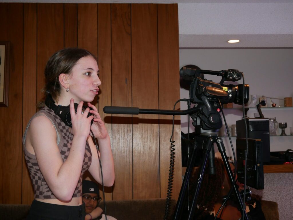 a woman standing next to a camera