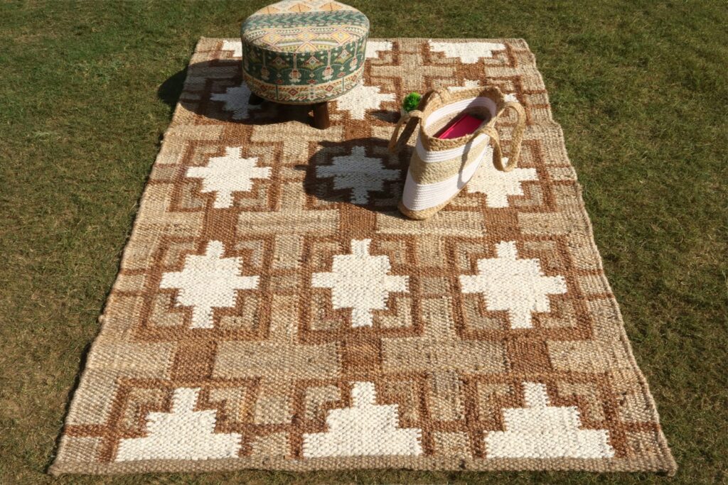A brown and white rug sitting on top of a grass covered field