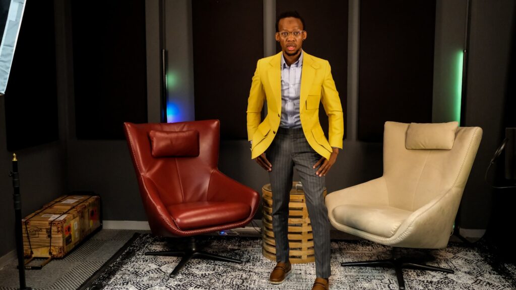 a man in a yellow jacket standing next to a chair