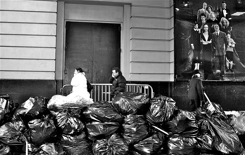 untitled (trash bags on a NYC sidewalk presided over by the Addam's Family)