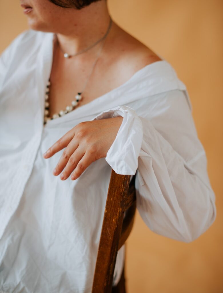 a woman in a white shirt is sitting on a chair