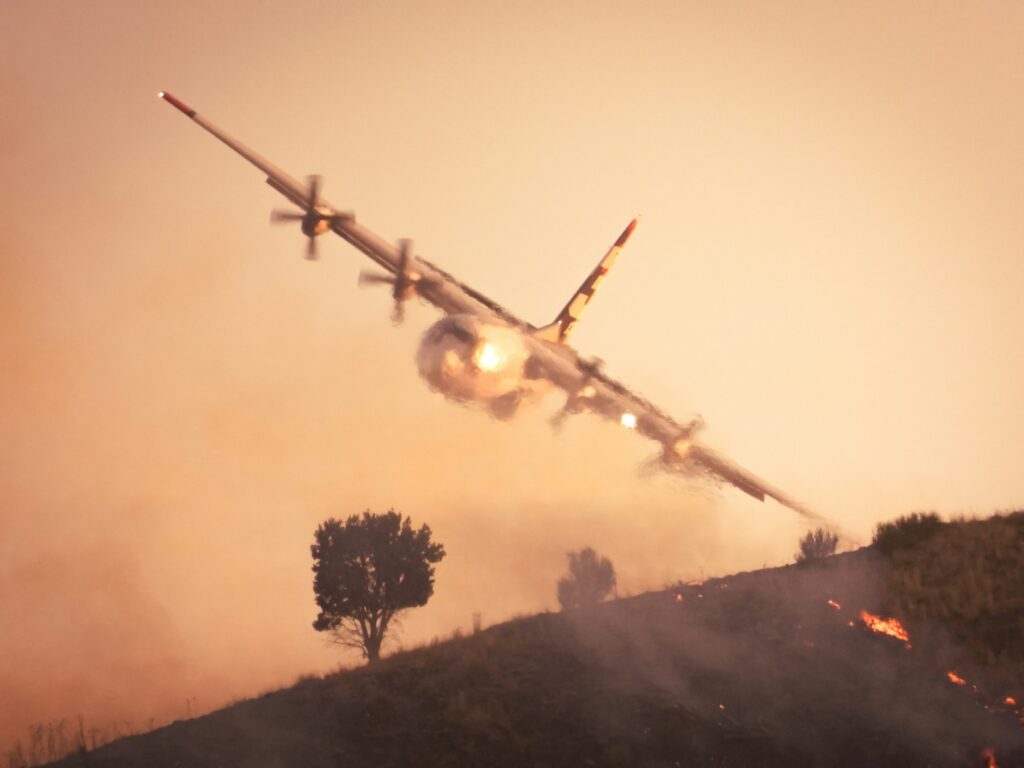 A plane is flying low over a hill