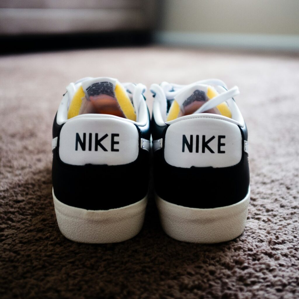 a pair of black and white nike shoes on a carpet