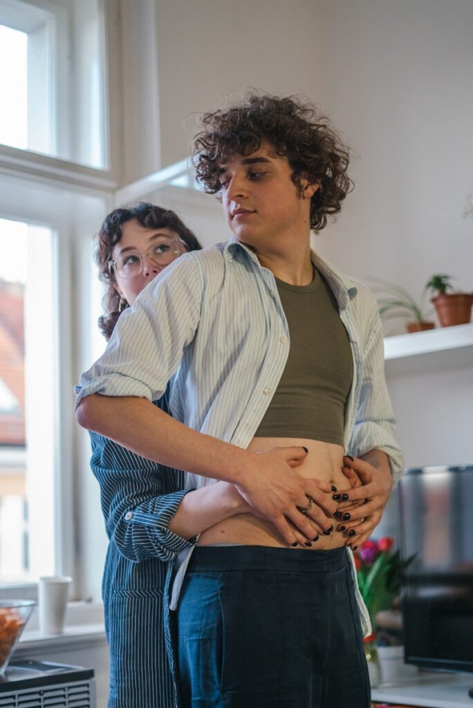 two people standing in a kitchen with one holding the other