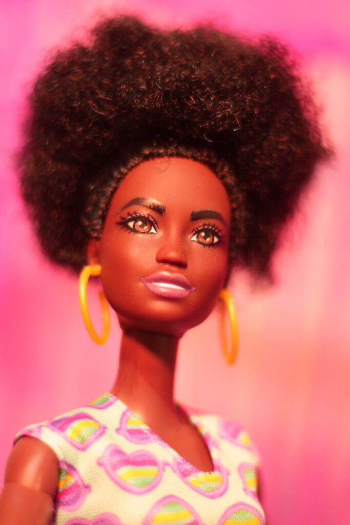A doll with brown skin and a large afro.