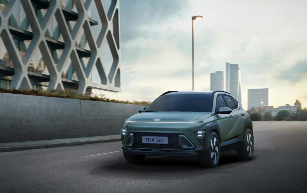 a green suv driving down a city street
