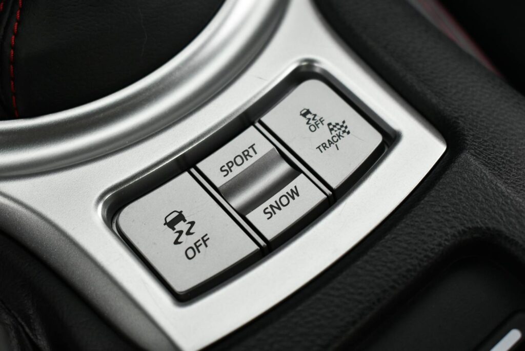Detailed image of car interior controls for sport and snow modes. Sleek and modern design.