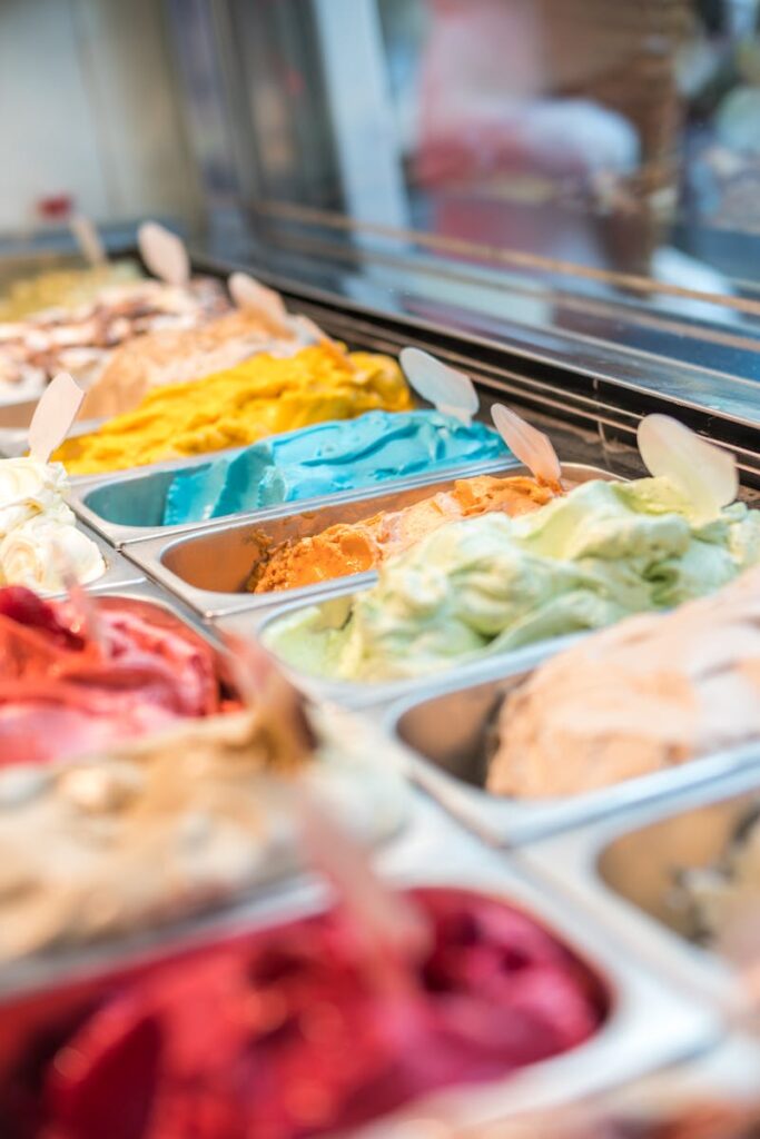 Colorful display of various gelato flavors in a modern ice cream parlor.