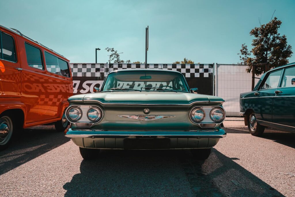 Front view of a vintage Chevrolet Corvair parked at an outdoor car show in Leiria, Portugal.
