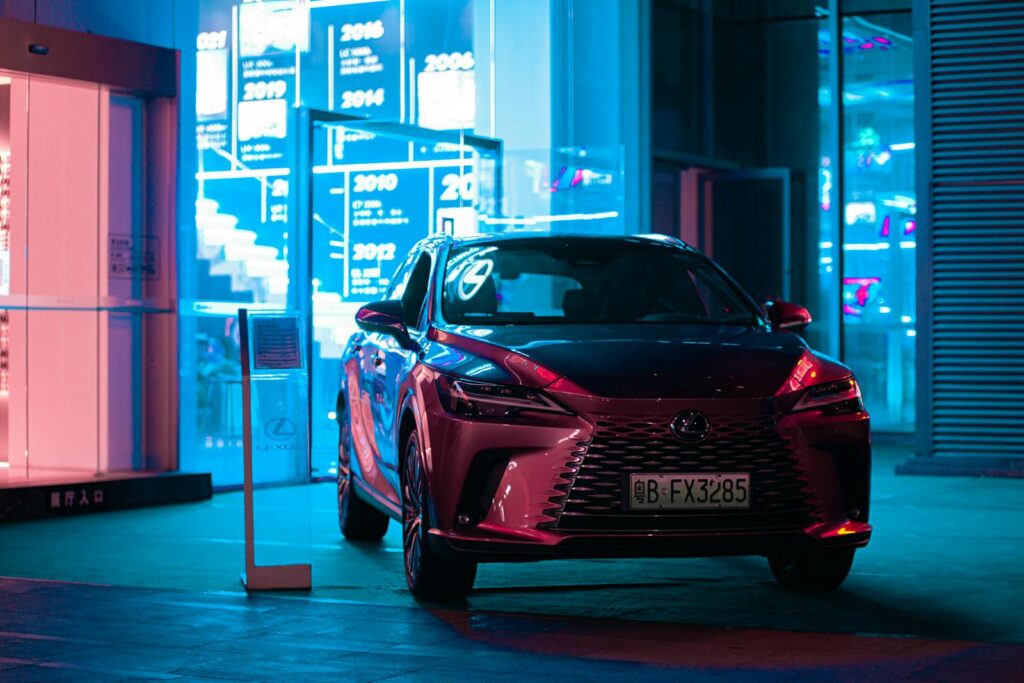 Stylish Lexus SUV parked at night, showcasing luxury in an urban landscape with vibrant neon lights.