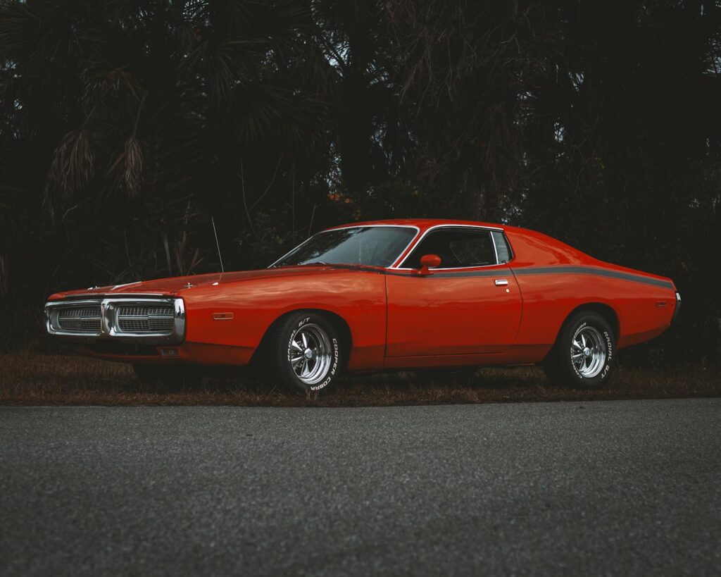 Classic red Dodge Charger parked by the roadside exuding nostalgia and vintage charm.