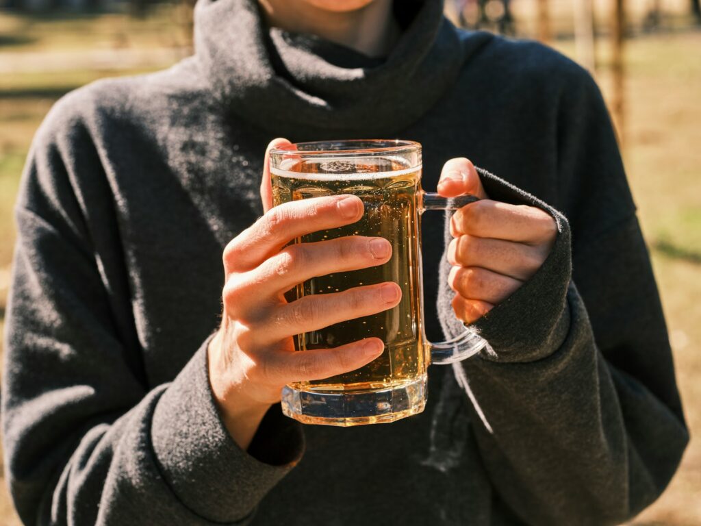a woman holding a glass of beer in her hands
