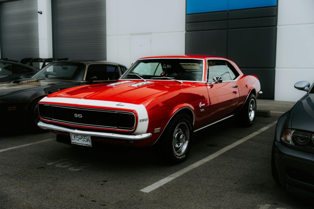 Classic red Camaro SS parked in an urban setting. Perfect for vintage car enthusiasts.