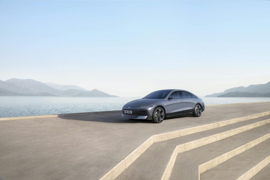Sleek Hyundai electric vehicle parked by a serene water view, emphasizing modern mobility and design.