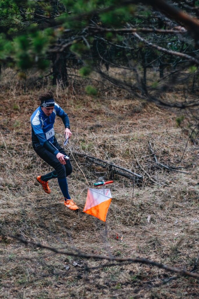 a man holding a kite in a wooded area