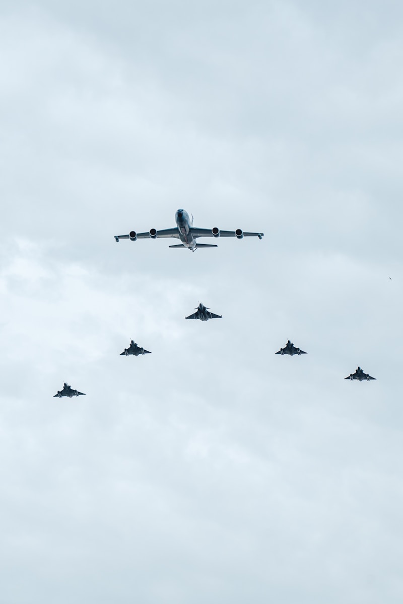 A formation of fighter jets flying through a cloudy sky
